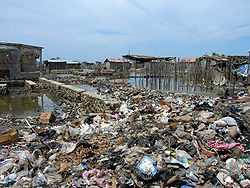 Des banlieues, des bidonvilles ou des routes (ici à Haïti) ont souvent été construits sur des zones humides comblées avec des déchets pour partie fermentescible, avec risques sanitaires, d'effondrement et d'explosion de poches de méthane.